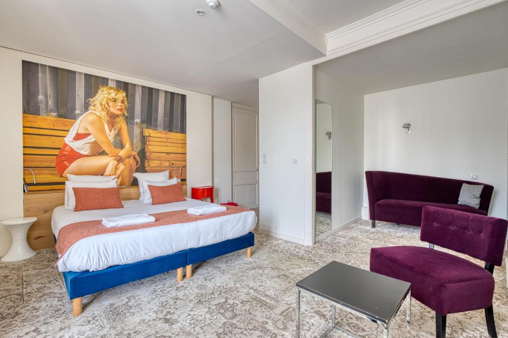 a bedroom with a bed and a painting of a woman at Hotel François 1er Cœur de Ville in La Rochelle