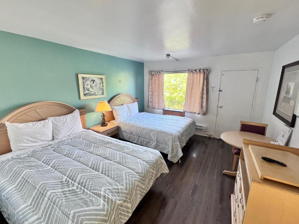 a hotel room with two beds and a window at 6267 Persepolis Inn in Niagara Falls