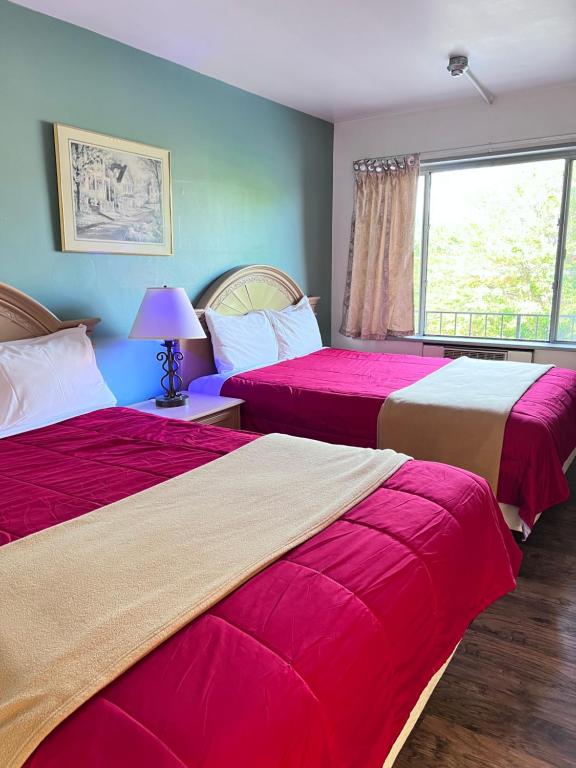 a bedroom with two beds and a window at 6267 Persepolis Inn in Niagara Falls