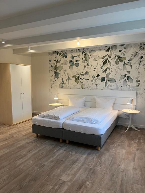 a bedroom with a bed and a floral wall at Ferienhof Pankalla in Neubruchhausen
