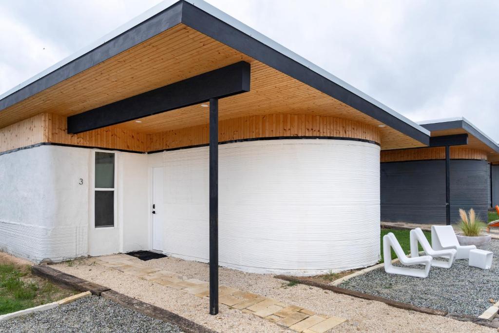 a garage with two white chairs in front of it at Casita 3 The Gomocita at The Halles Artisan Venue in Round Top