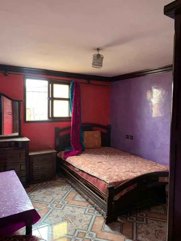 una camera con due letti e pareti viola di Klmmm ad Agadir