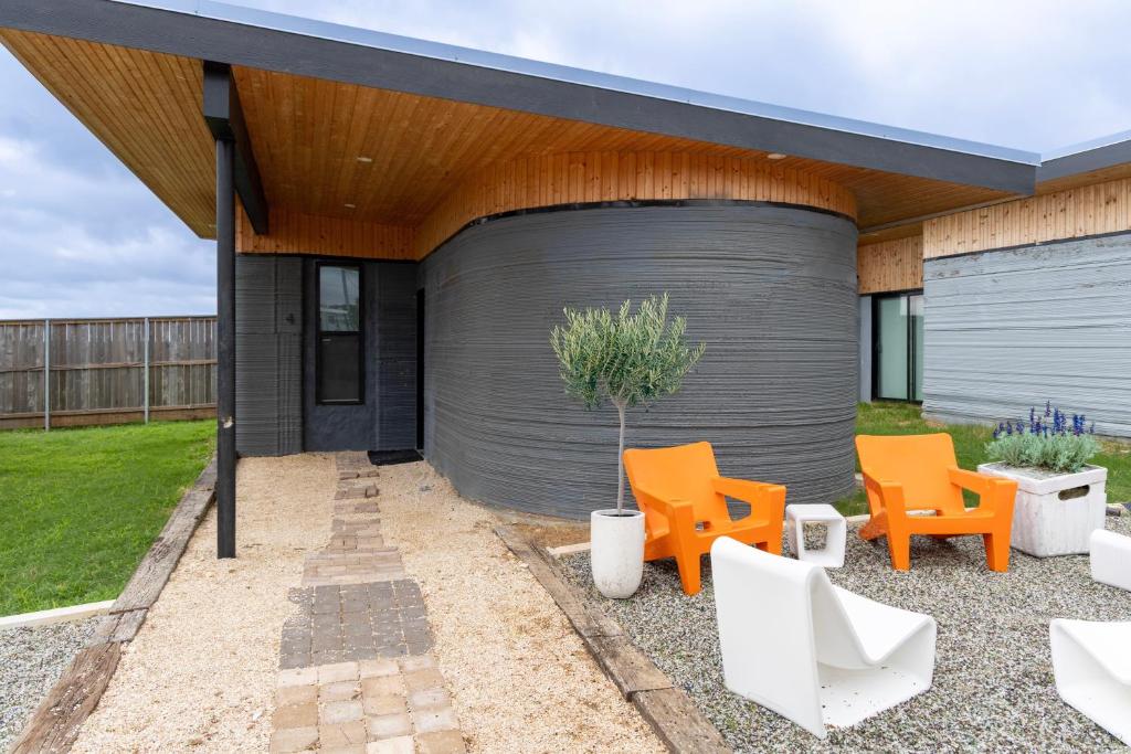 a building with orange and white chairs in front of it at Casita 4 Cisco Home at The Halles Artisan Venue in Round Top