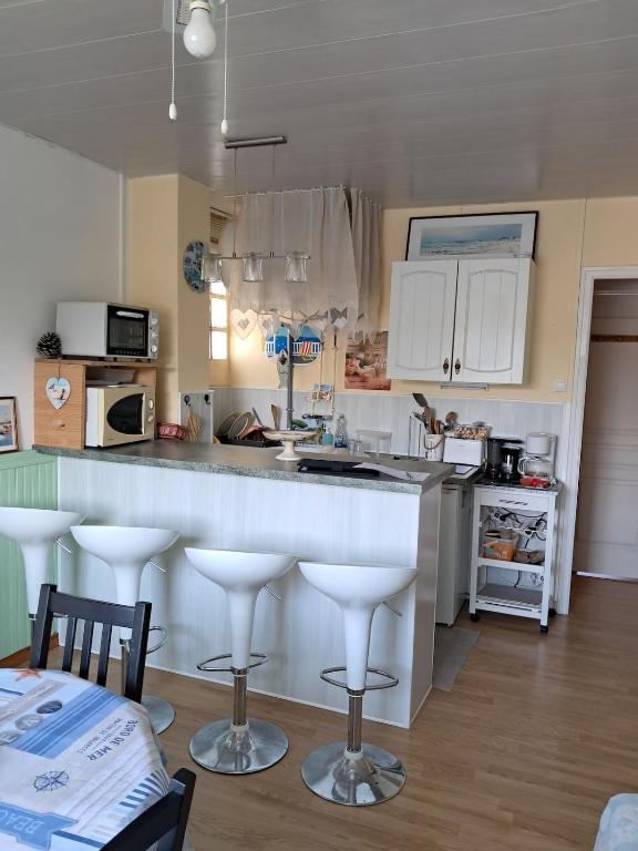 une cuisine avec un comptoir et quelques tabourets de bar dans l'établissement Le Marquenterre, à Quend-Plage