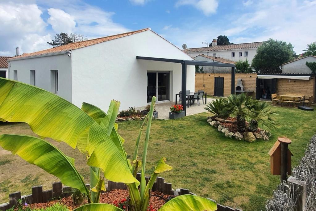 une maison blanche avec une grande cour dans l'établissement Maison de plain-pied 3 chambres classée 4 étoiles dans impasse au calme, à La Guérinière