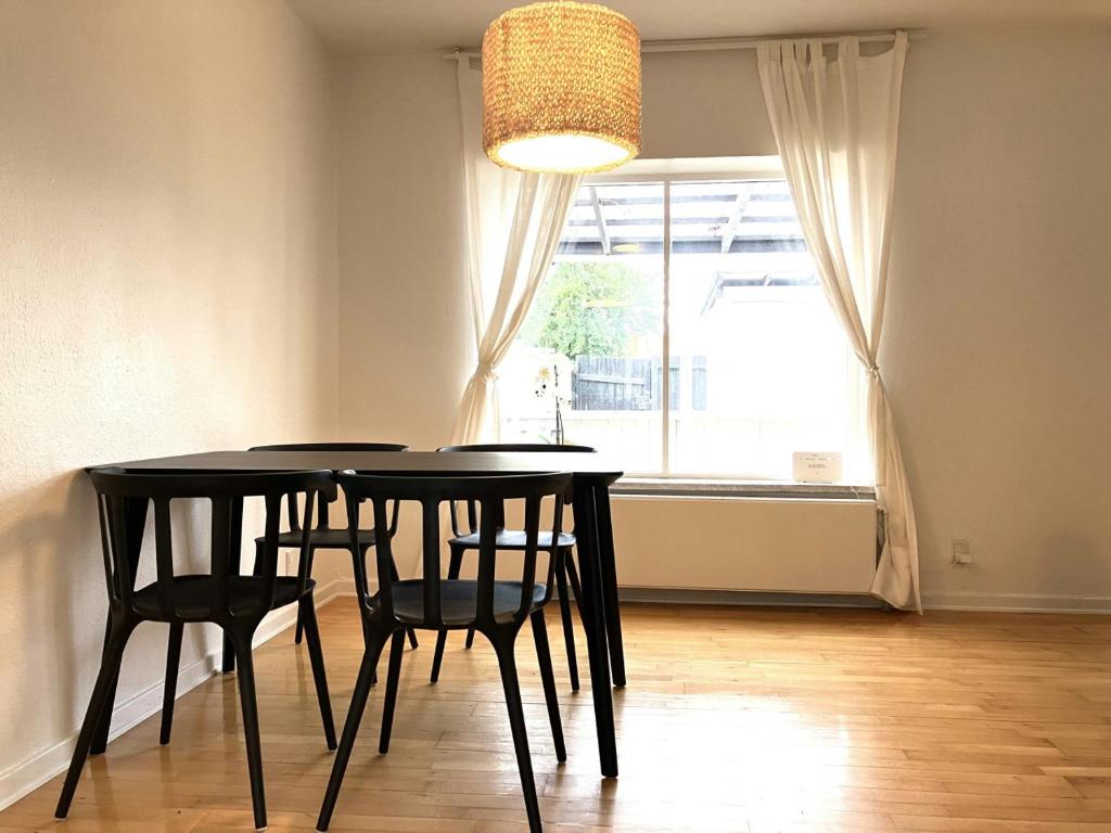 a dining room table with two chairs and a window at Spacious Apartment for 5 in Odense