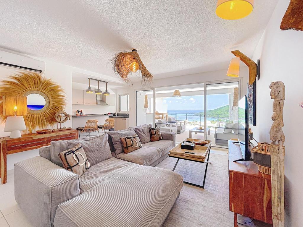 a living room with a couch and a table at Koala1 Elegant 1BR Duplex, Anse Marcel, Sea View in Anse Marcel 