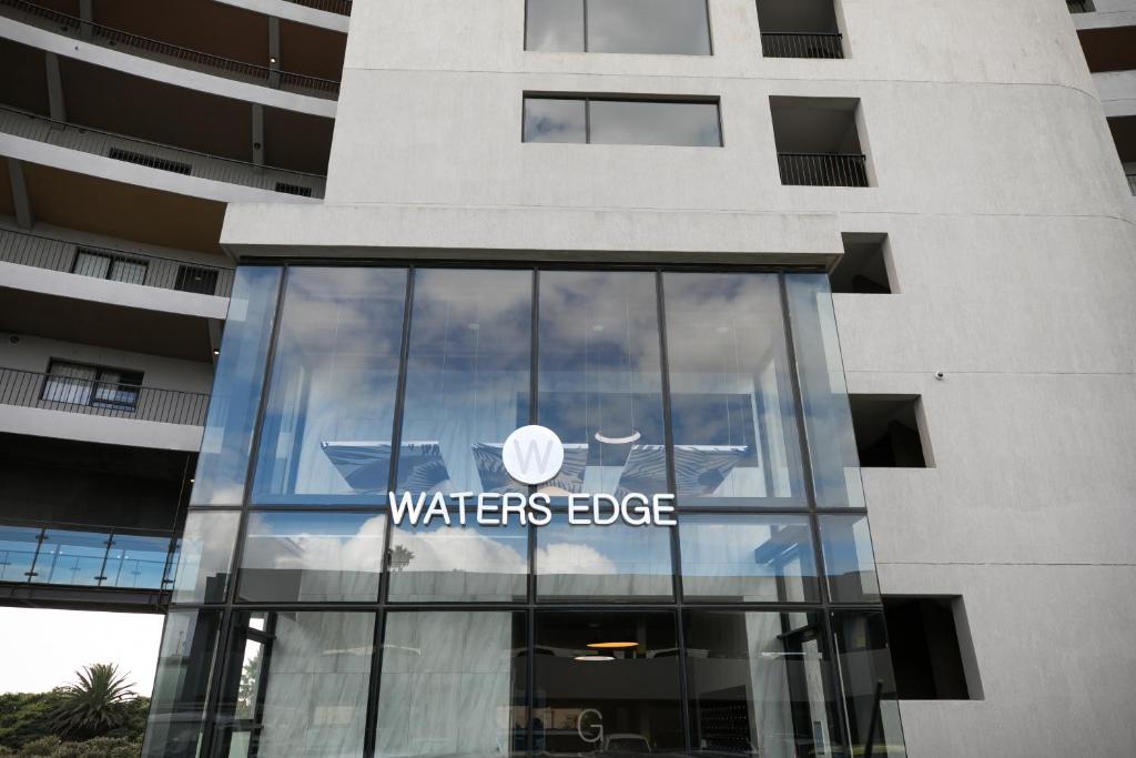 a waterless edge sign on the side of a building at 2 Bedroom Waters Edge Apartment in Century City in Cape Town
