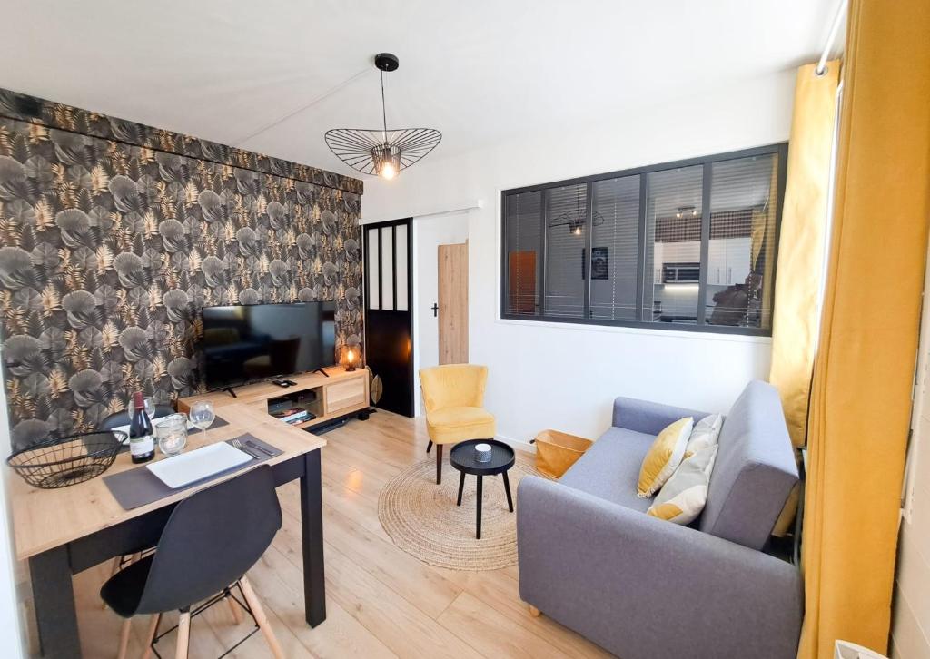 een woonkamer met een bank en een tafel bij Les Amoureux in Royan