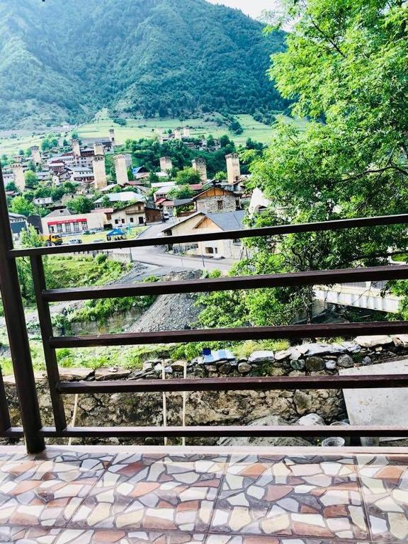 a balcony with a view of a town and a mountain at guest house dede in Itʼkhvisi