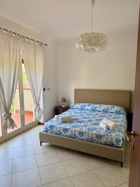 a bedroom with a bed and a chandelier at Heliomar Naxos - Your Balcony on the Sea in Giardini Naxos