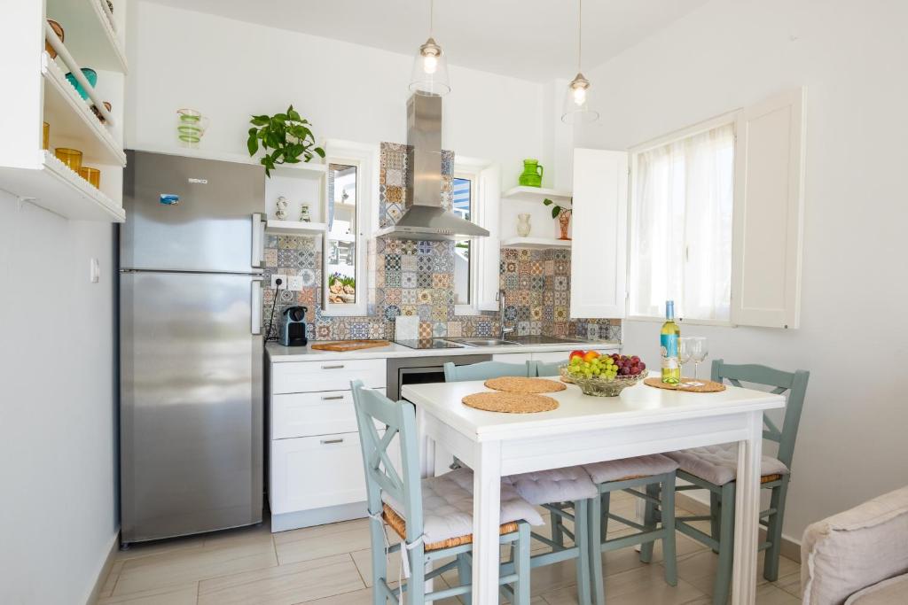 a kitchen with a white table and a refrigerator at Silene Villas in Amoopi