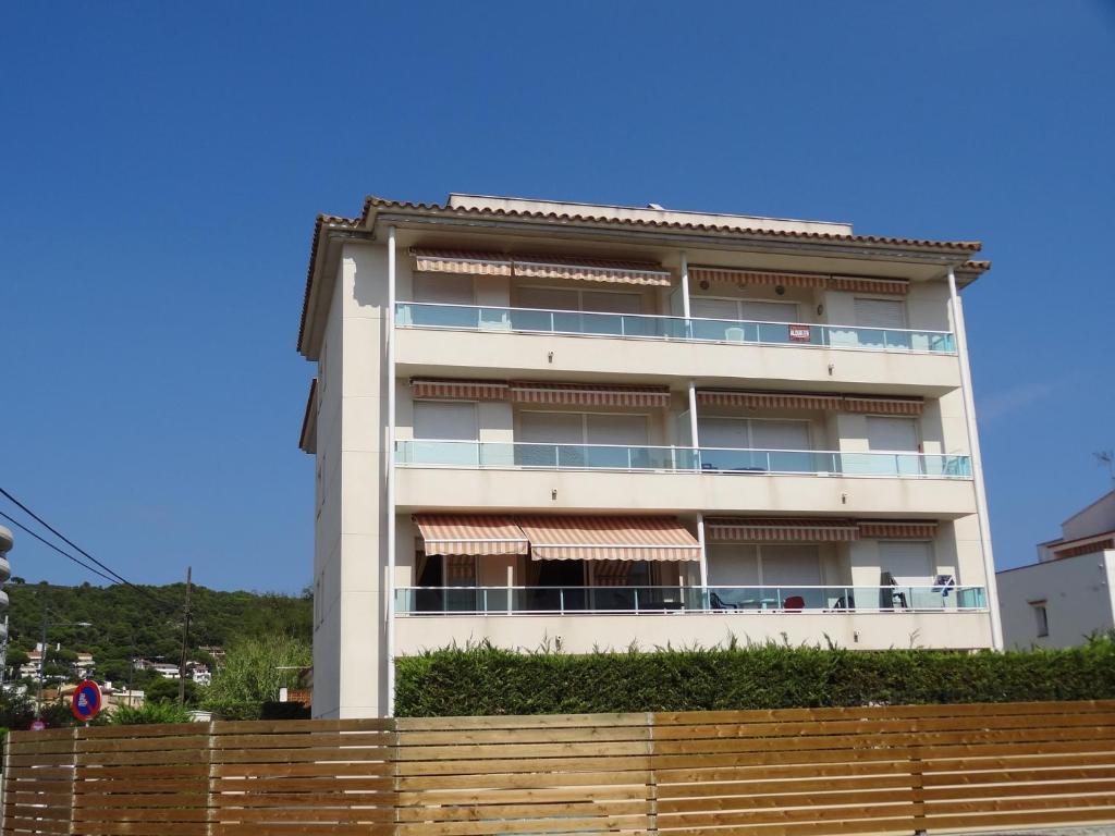 a white building with a fence in front of it at Apartamentos Las Brisas 3-2 in Torroella de Montgrí