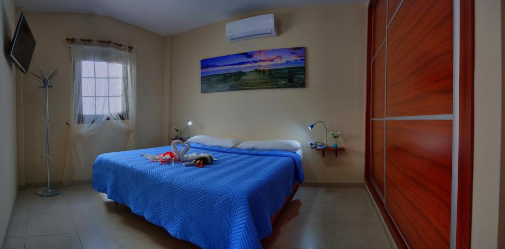 a bedroom with a blue bed with toys on it at Casa Yoel in Granadilla de Abona