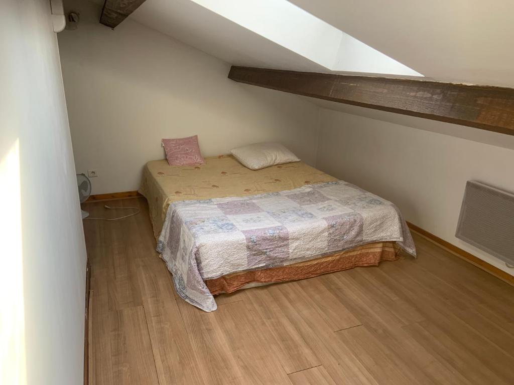 une petite chambre avec un lit dans un grenier dans l'établissement Colocation maison avec piscine vélodrome, à Marseille