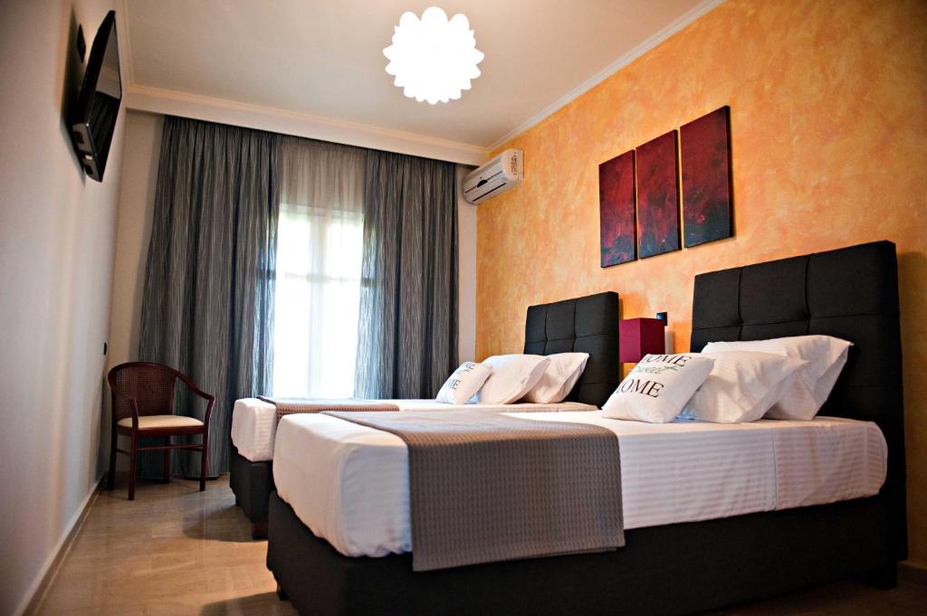 エルモネスにあるSerenita Apartmentsのベッド2台と窓が備わるホテルルームです。