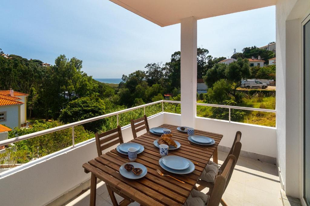 a wooden table on the balcony of a house at WHome Modern House With Balcony & AC Close To The Sea in Alcabideche