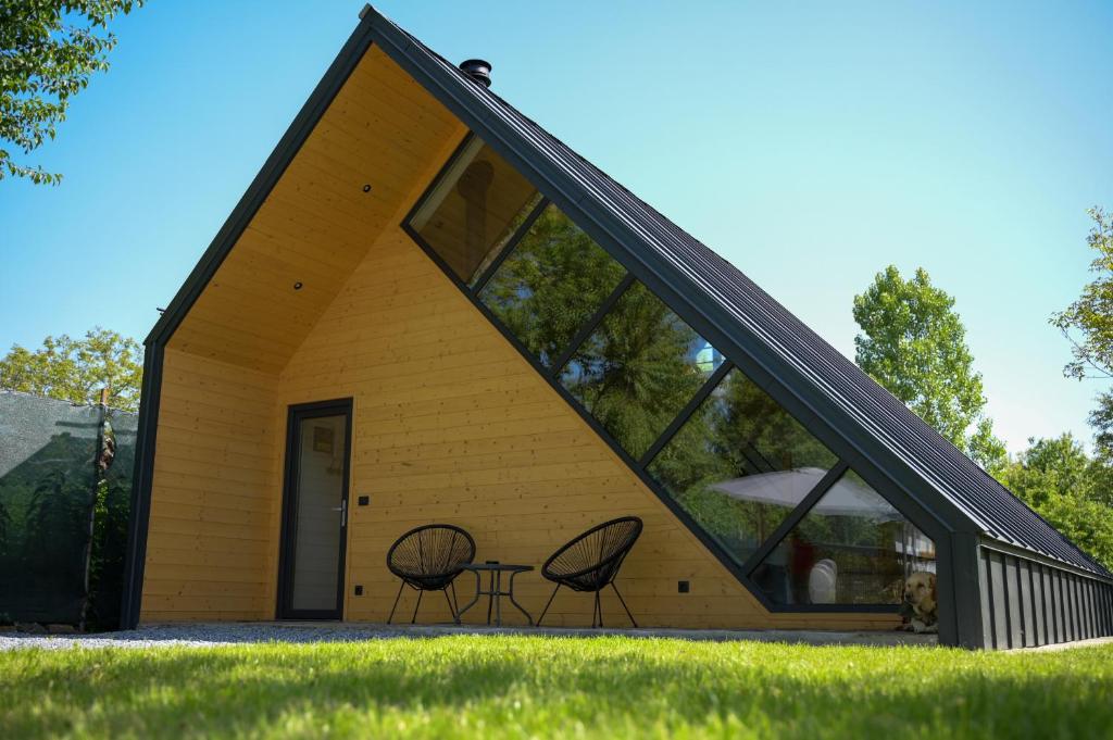 dom z trójkątnym dachem z dwoma krzesłami w obiekcie La Livada Chalet w mieście Vişeu de Sus