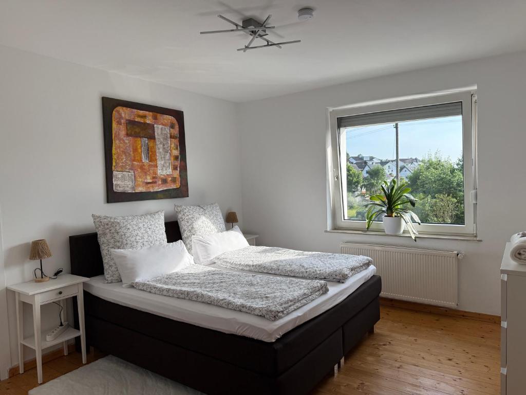 a bedroom with a bed and a window at Gartenstübche in Siegen