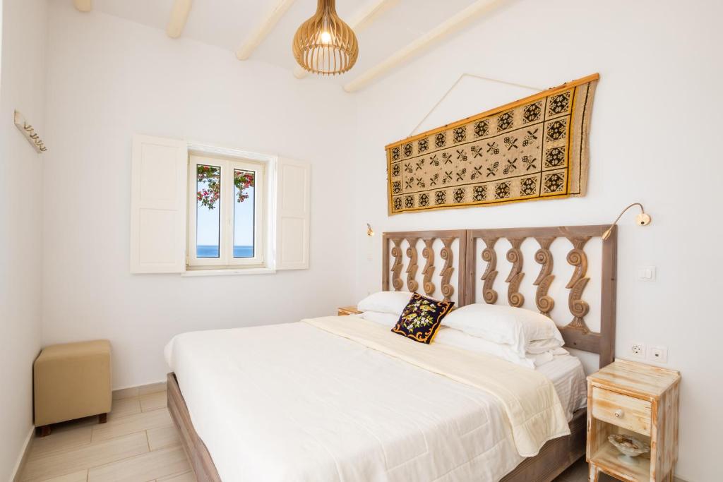 a white bedroom with a bed and a window at Silene Villas in Amoopi