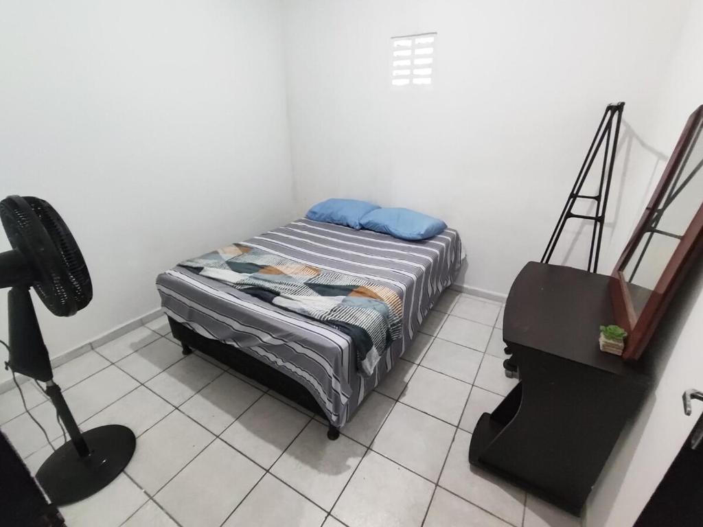a small bedroom with a bed and a desk at Ap 2 quartos com vaga de garagem in Campina Grande
