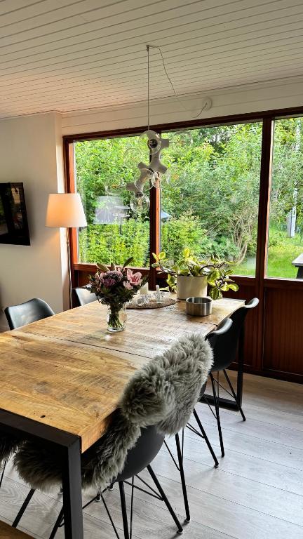 a dining room table with chairs and a large window at Melby-Liseleje-Frederiksværk in Melby