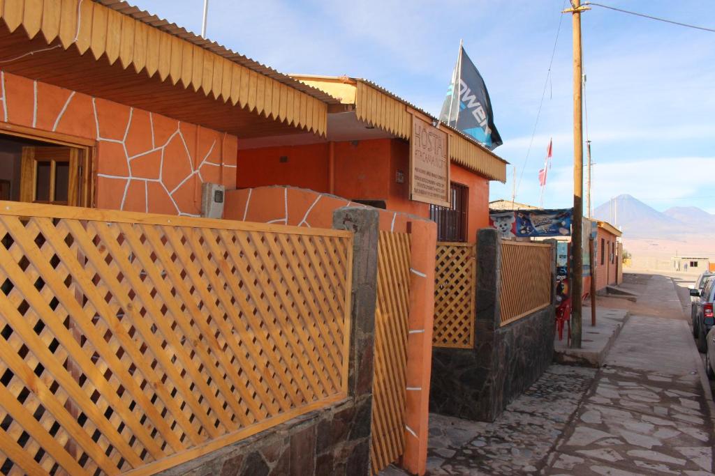 un edificio con una valla naranja junto a una calle en Hostal Atacama North en San Pedro de Atacama
