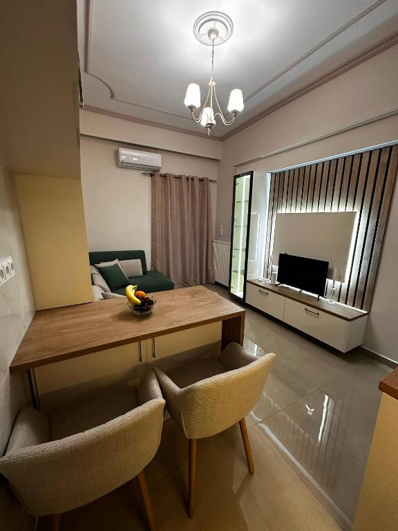 a living room with a table and chairs and a television at D&S Coastal Stay in Korinthos in Korinthos