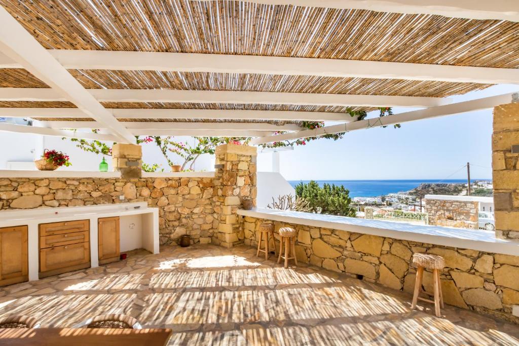 a patio with a counter and a stone wall at Silene Villas in Amoopi