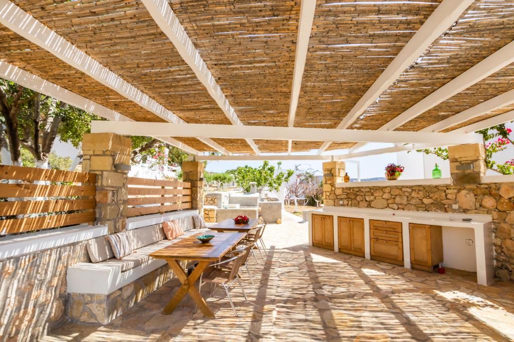 an outdoor patio with a wooden table and a bench at Silene Villas in Amoopi