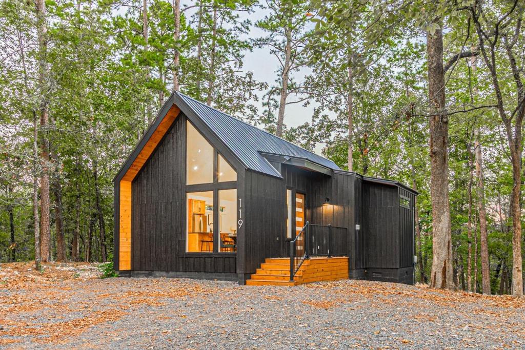 een zwart tiny house in the woods bij The Echo - Forest Romance with Sunken Hot Tub Underneath the Starlit Night in Broken Bow