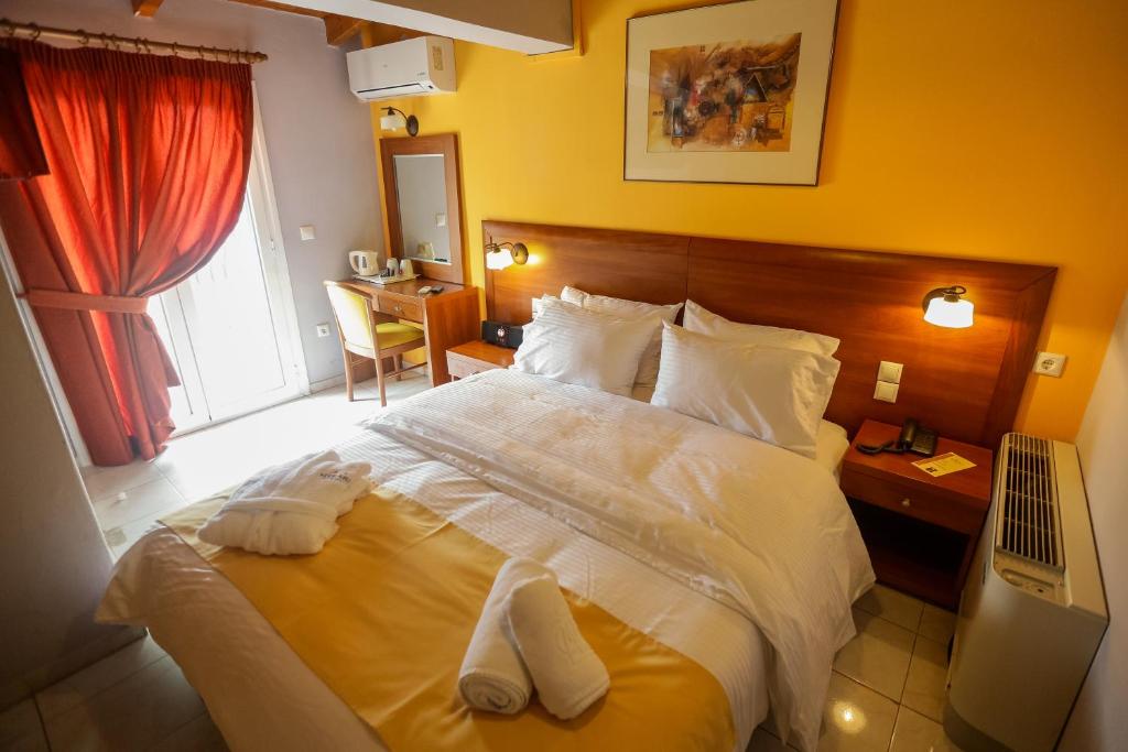 Mirabel CityCenter Hotel في أرغوستولي: غرفة نوم بسرير كبير عليها مناشف