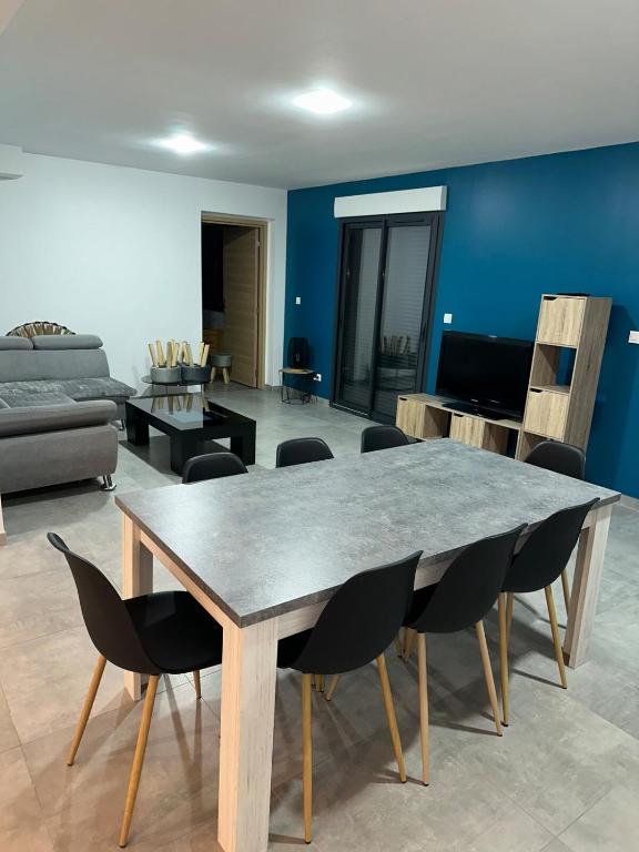 - un salon avec une grande table et des chaises en bois dans l'établissement La Résidence Degas 4 chambres, à Joué-lès-Tours