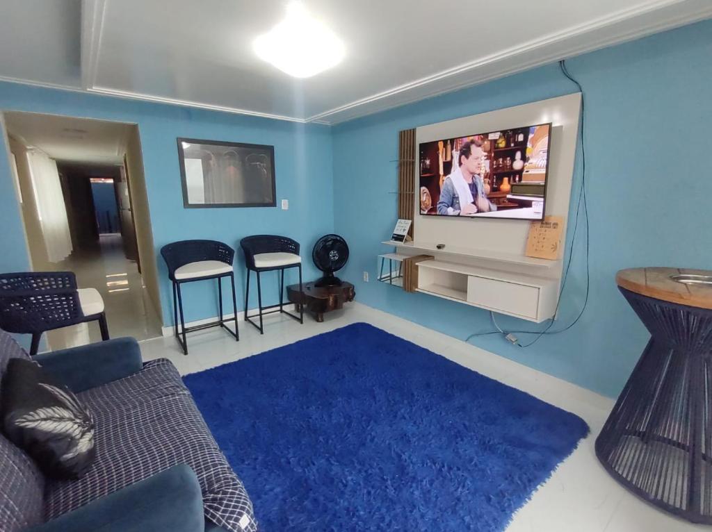 un soggiorno con divano e TV a schermo piatto di Apto pé na Areia a Ilha do Frade