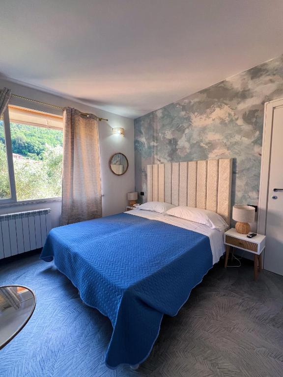 una camera da letto con un letto blu con una coperta blu di Hotel Le Grazie a Portovenere