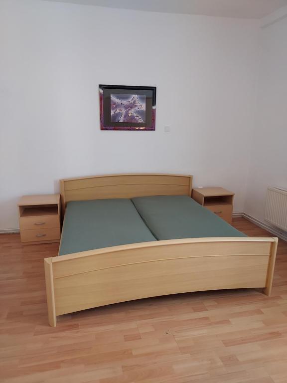 a wooden bed in a room with a picture on the wall at Apartmán v okresu Děčin 