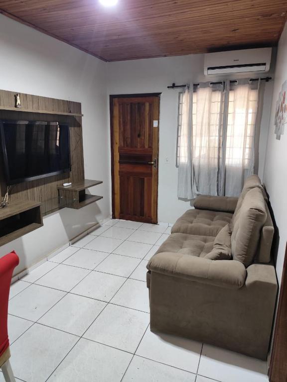 a living room with a couch and a flat screen tv at Casa perto da Uopecan in Cascavel