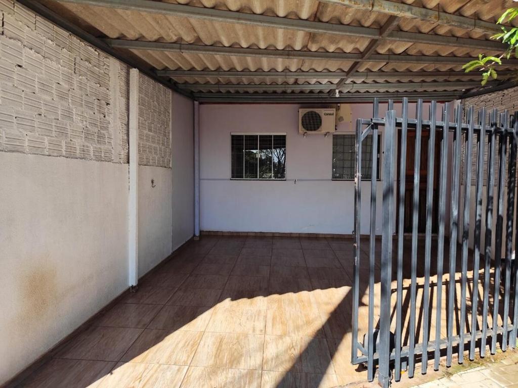 Un garaje vacío con una puerta y un aro de baloncesto. en Casa perto da Uopecan, en Cascavel