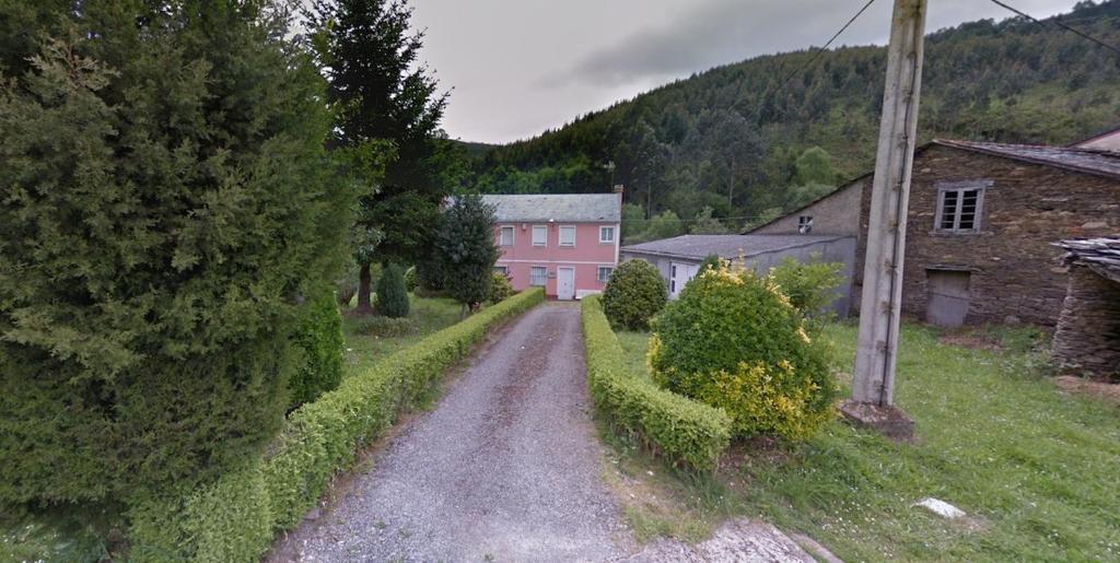 TrabadaにあるCasa de Campo en Xuga, Trabadaのピンク色の家がある村の未舗装道路