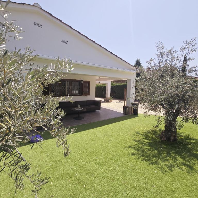 a white house with a yard with a couch at Costabravasuites villa can duk in Caldes de Malavella