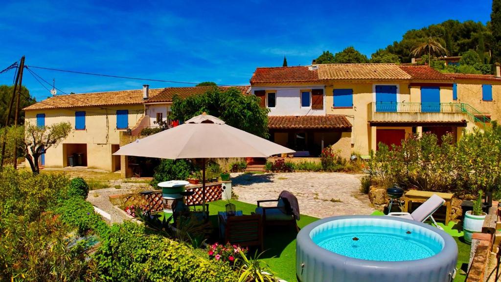 une maison avec un parasol et une piscine dans l'établissement Mas provençal vue mer à 5 min de la plage, à Sanary-sur-Mer