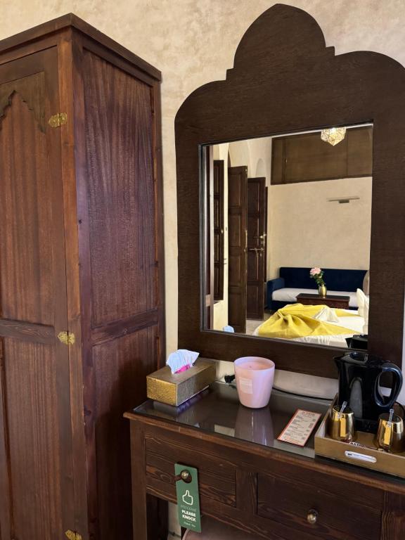 a bedroom with a dresser with a large mirror at Riad M'Barka in Tangier