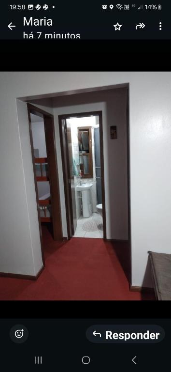 a picture of a bathroom with a door open at Ap confortável in Tramandaí