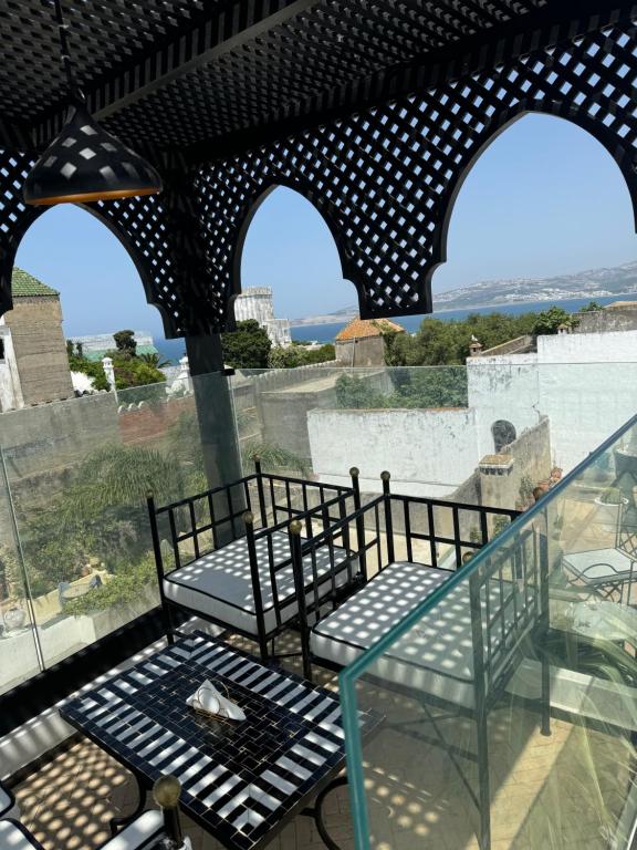 a balcony with two chairs and a glass railing at Riad M'Barka in Tangier