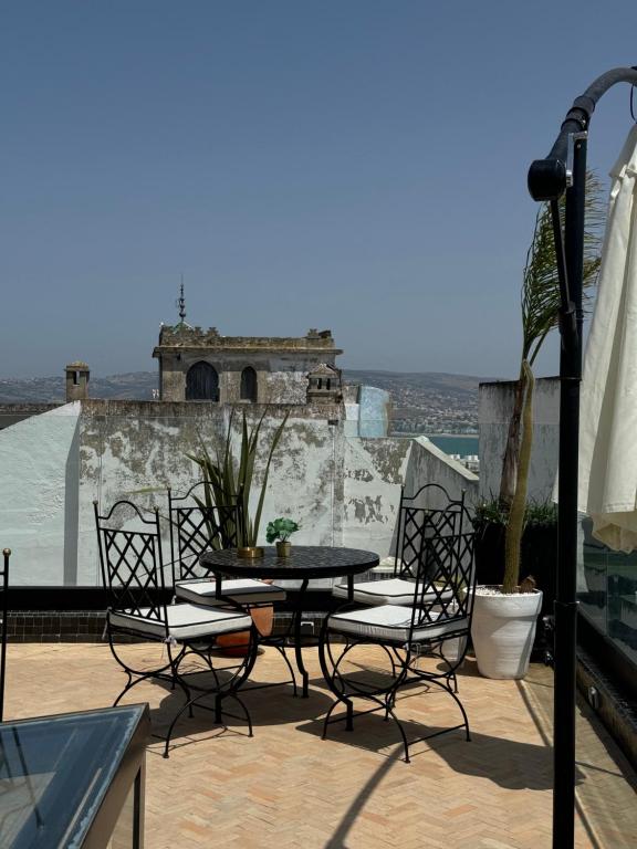 a patio with a table and chairs on a roof at Riad M'Barka in Tangier
