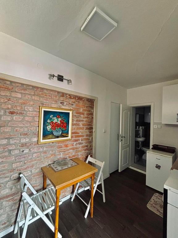 a room with a table and chairs and a brick wall at Villa Flora Apartments Krushevo in Kruševo