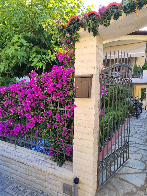 a fence with purple flowers on it at SOLMAR HOUSE in Flogita