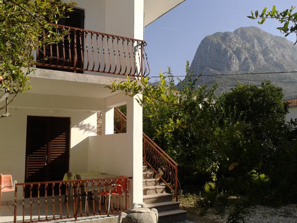 a house with stairs and a mountain in the background at Apartments Tamaris in Zaostrog