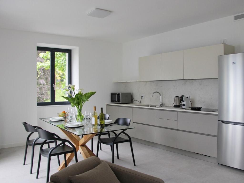 a kitchen with a table and chairs and a refrigerator at Il Porticciolo in Lezzeno