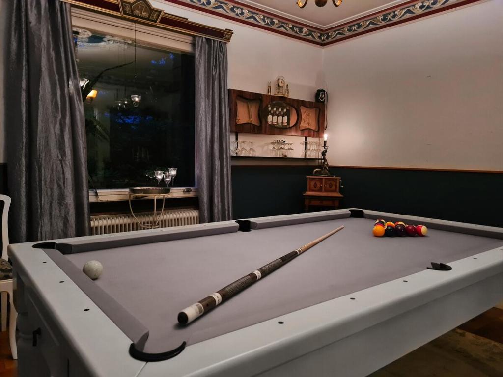 a pool table with two bats and balls on it at Romantic get-away in Mölnlycke